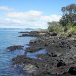 Rangtito szigete a nagyváros mellett - kék ég és fekete láva